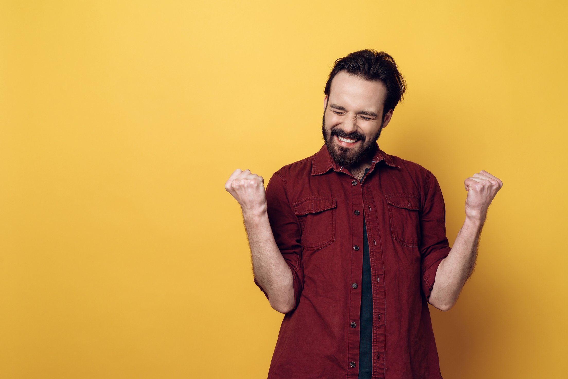 Portrait of Happy Bearded Man Clenching Fists